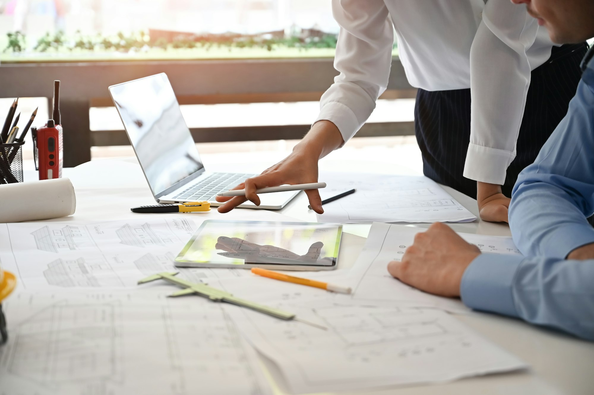 Team architect meeting and consult with blueprint and computer in architecture office.